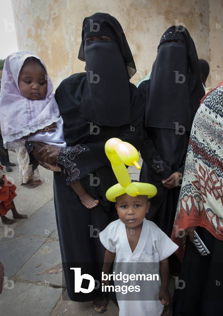 Young woman wearing hijab and child boy with ballon on headin lamu, Kenya, Africa (photo)