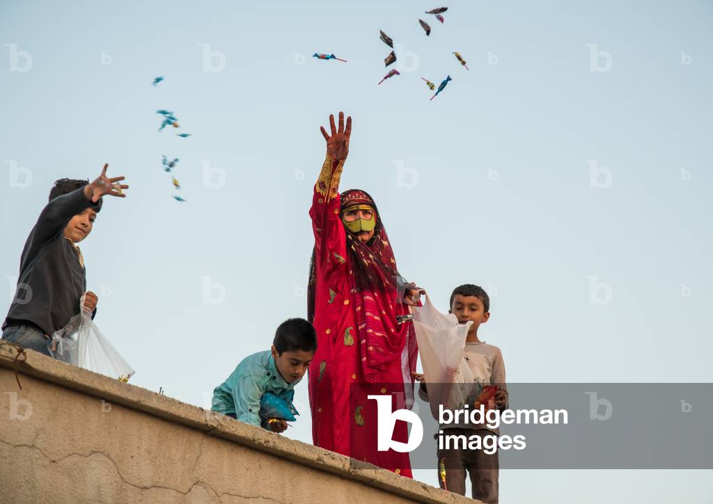 Women With Face Masks Throwing Sweets To Kids During A Wedding, Hormozgan, Kushkenar, Iran, 2015 (photo)