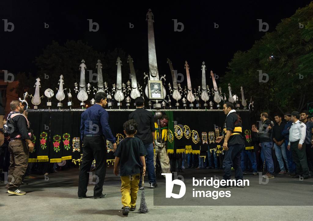 Iranian shiite muslim men carrying an alam during Muharram, Lorestan Province, Khorramabad, Iran (photo)