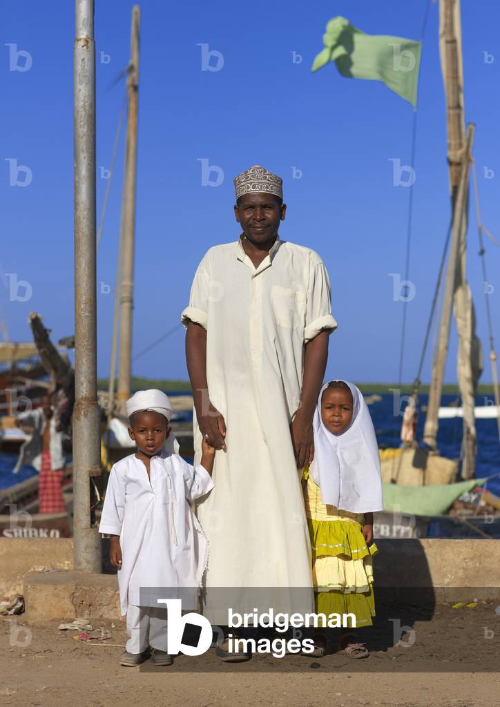 A father and his two young children in the dockside of lamu, Kenya, Africa (photo)