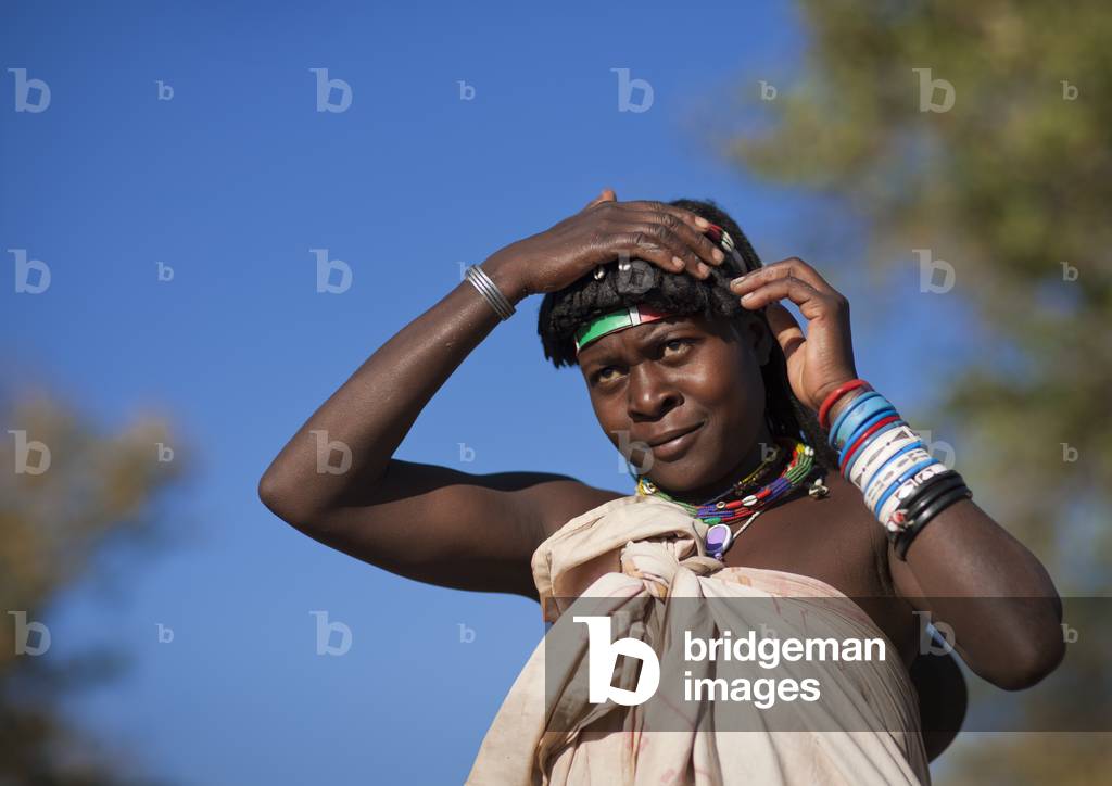 Mucawana Woman Combing her Hair, Village of Oncocua, Angola, Africa (photo)