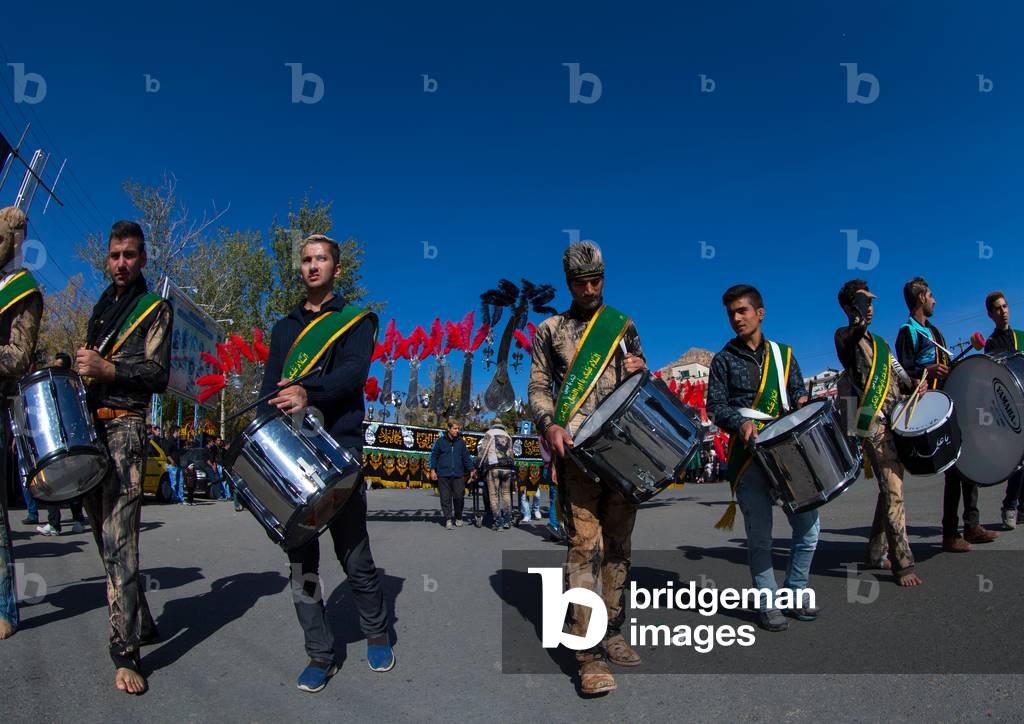 Iranian Shiite Muslim Men Playing Drums in front of an Alam during Ashura, Kurdistan Province, Bijar, Iran (photo)