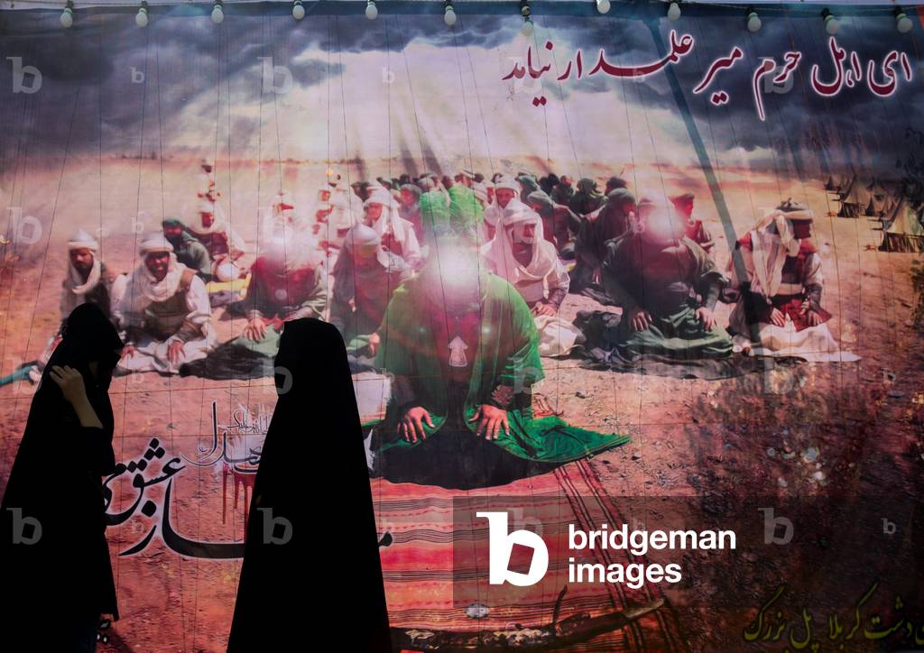 Iranian Shiite Women in front of a Banner of Imam Hussein with Face Erased during Ashura Celebration, the Day of the Death of Hussein, Lorestan Province, Khorramabad, Iran (photo)