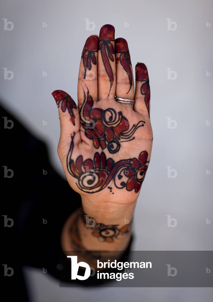 Human palm of hand and forearm of woman drawing patterns with henna and indigo blue, Maulidi festival, Lamu Kenya, Africa (photo)