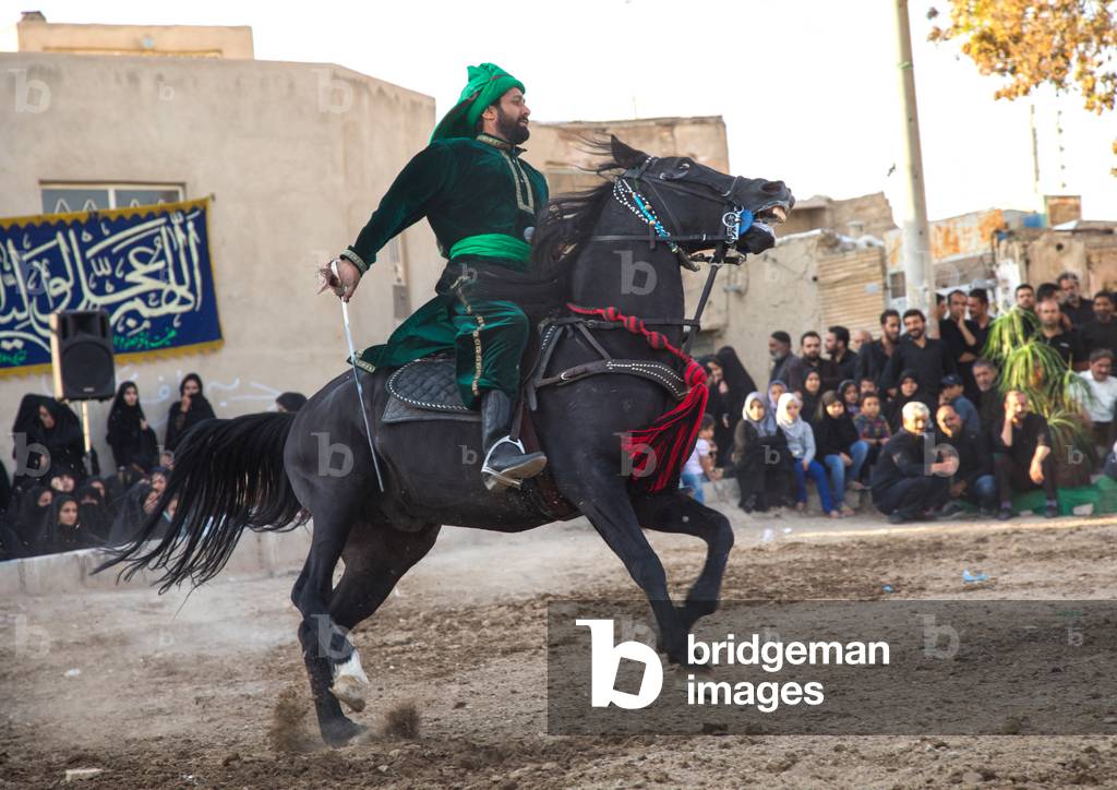 Man riding a horse during a traditional religious theatre called tazieh about Imam Hussein death in Kerbala, Isfahan Province, Isfahan, Iran (photo)