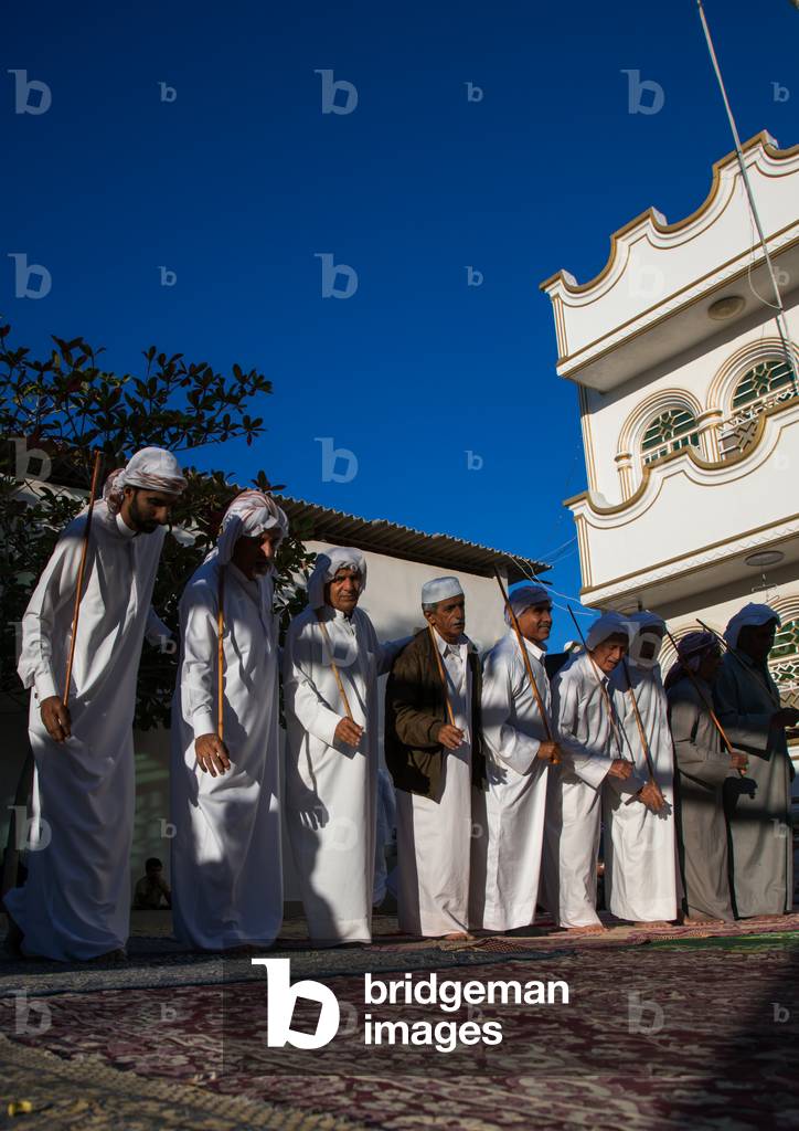 Men Dressed In White Dancing With Sticks During A Wedding Ceremony, Hormozgan, Bandar-E Kong, Iran, 2015 (photo)
