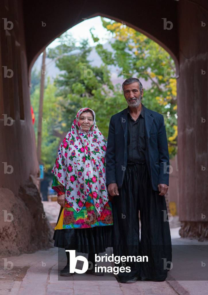 Portrait of an Iranian Woman wearing Traditional Floreal Chador with her Husband in Zoroastrian Village, Isfahan Province, Abyaneh, Iran (photo)