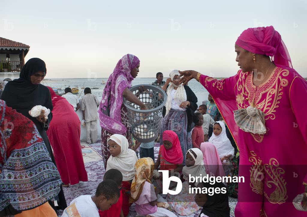 Woman giving food during maulidi festival, Lamu, Kenya, Africa (photo)
