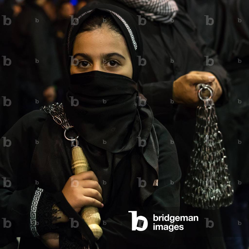 Iranian shiite muslim girl beating herself with iron chains during Muharram, Lorestan Province, Khorramabad, Iran (photo)