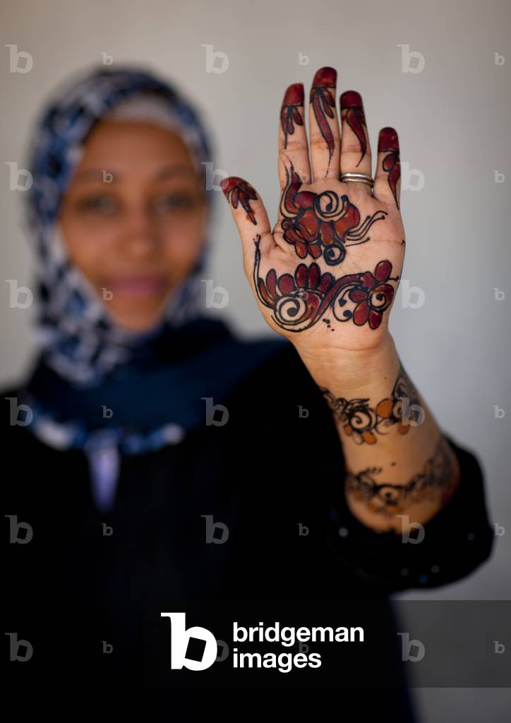 Unrecognizable young woman showing palm of her hand painted with henna and indigo blue, Lamu, Kenya, Africa (photo)