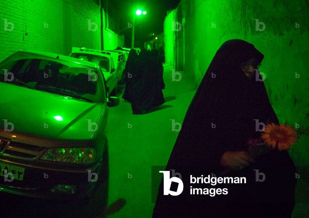 Iranian Women wearing Chadors in the Street Lighten by Green Light during Muharram Celebration, Isfahan Province, Kashan, Iran (photo)