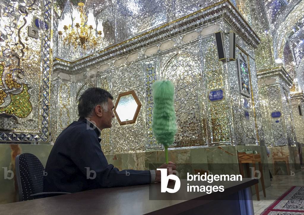 Guard with a green feather duster at The Shah-e-Cheragh Mausoleum, Fars province, Shiraz, Iran (photo)