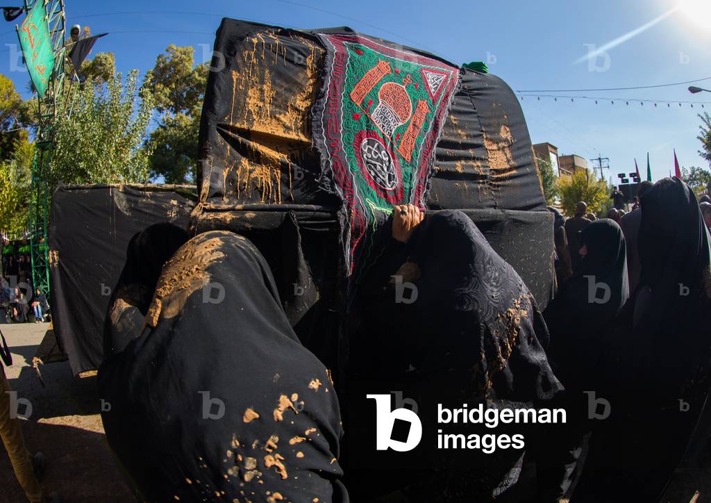 Iranian Shiite Muslim Women Covered in Mud Crying in front of a Coffin during Ashura, Kurdistan Province, Bijar, Iran (photo)