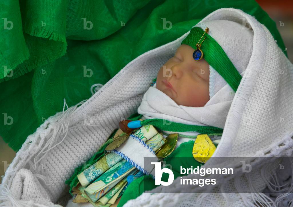 A Baby Doll with Bank Notes Attached on His Belt during Tasua Celebrations one day before Ashura, Lorestan Province, Khorramabad, Iran (photo)