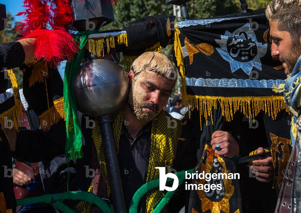 Iranian Shiite Muslim Man Covered in Mud Carrying an Alam during Ashura Day, Kurdistan Province, Bijar, Iran (photo)