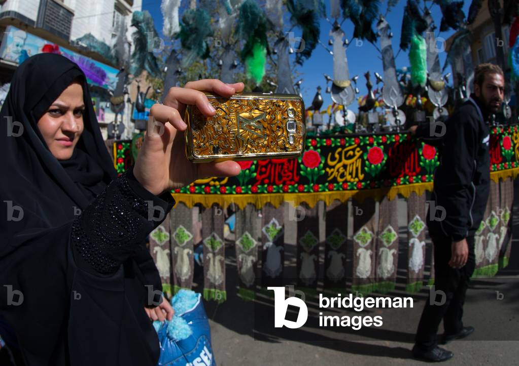 Iranian Woman Taking Pictures with a Mobile Phone Branded Louis Vuitton during Ashura, Kurdistan Province, Bijar, Iran (photo)