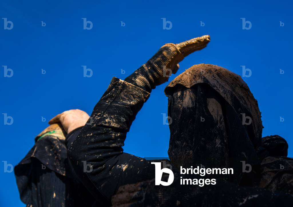 Iranian Shiite Muslim Woman Covered in Mud, Chanting and Self-flagellating during Ashura, Kurdistan Province, Bijar, Iran (photo)