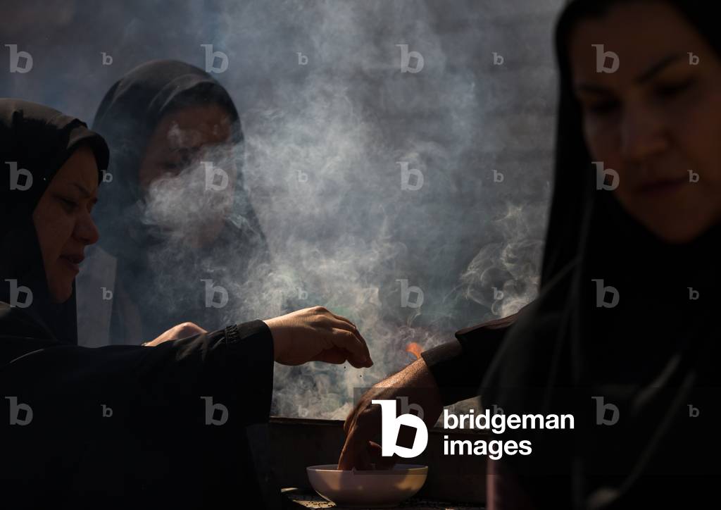 Shia Muslim Women Lighting Incense during Chehel Menbari Festival on Tasua Day for Ashura Celebration, Lorestan Province, Khorramabad, Iran (photo)