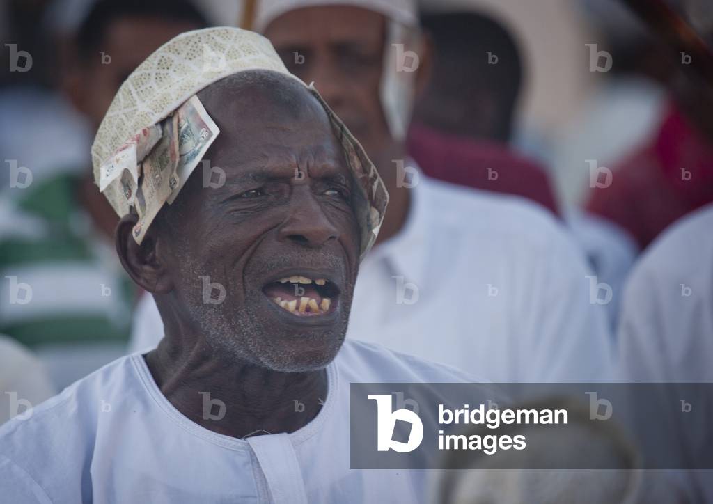 Senior man singing and directing goma stick dance at maulidi festival, Lamu, Kenya, Africa (photo)