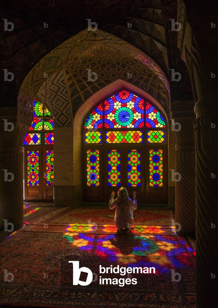 Iranian Woman Praying in the Nasir Ol Molk Mosque with Its Beautiful Coloured Glass Windows, Fars Province, Shiraz, Iran (photo)