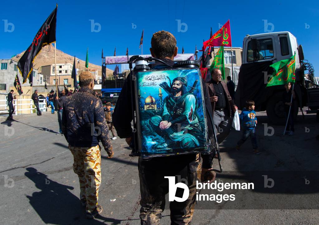 Iranian Shiite Muslim Man Carrying a Tank of Rose Water with Iman Hussein Representation on It during Ashura, Kurdistan Province, Bijar, Iran (photo)