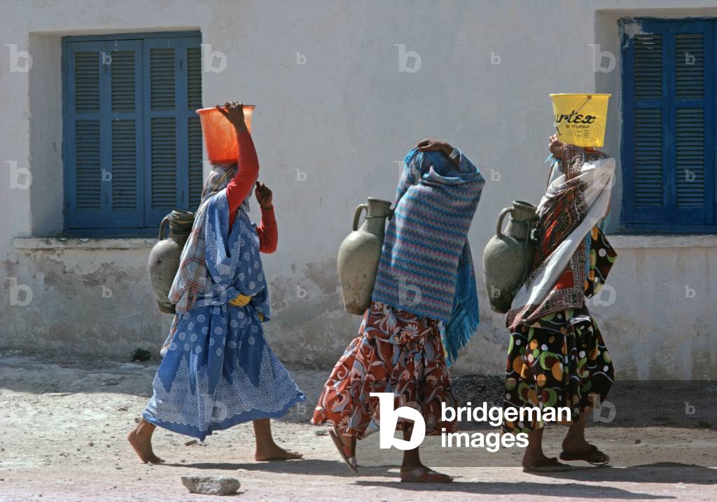 Tunisian Arab Berber women on their way to the Tozeur oasis to collect water in their amphora clay vessels  (photo)