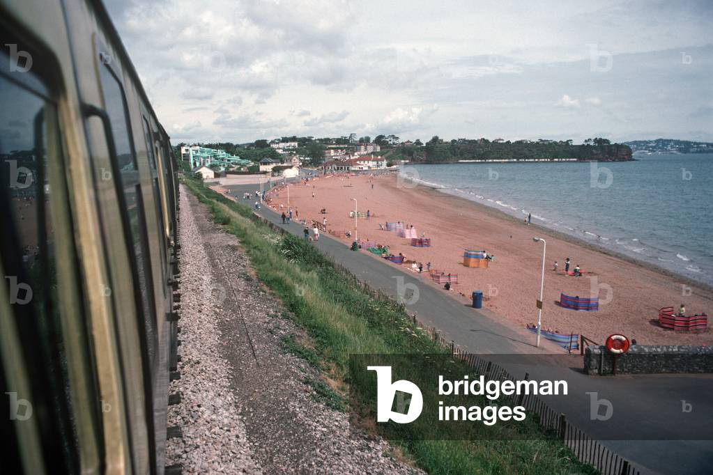 Steam train of the Heritage Dartmouth Steam Railway pass Goodrington Sands, Devon, England, UK, 1989 (photo)