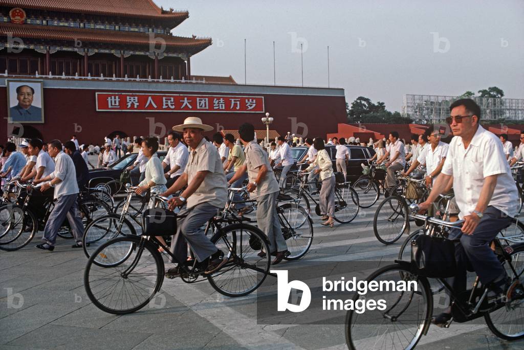 Cyclists in front of Forbidden City with portrait of Chairman Mao, Tiananmen Square, Beijing, China (photo)