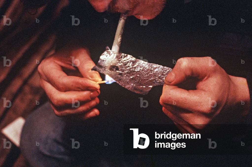 Drug addict cutting class A drugs,heroin, either to smoke or inject, Liverpool, UK (photo)