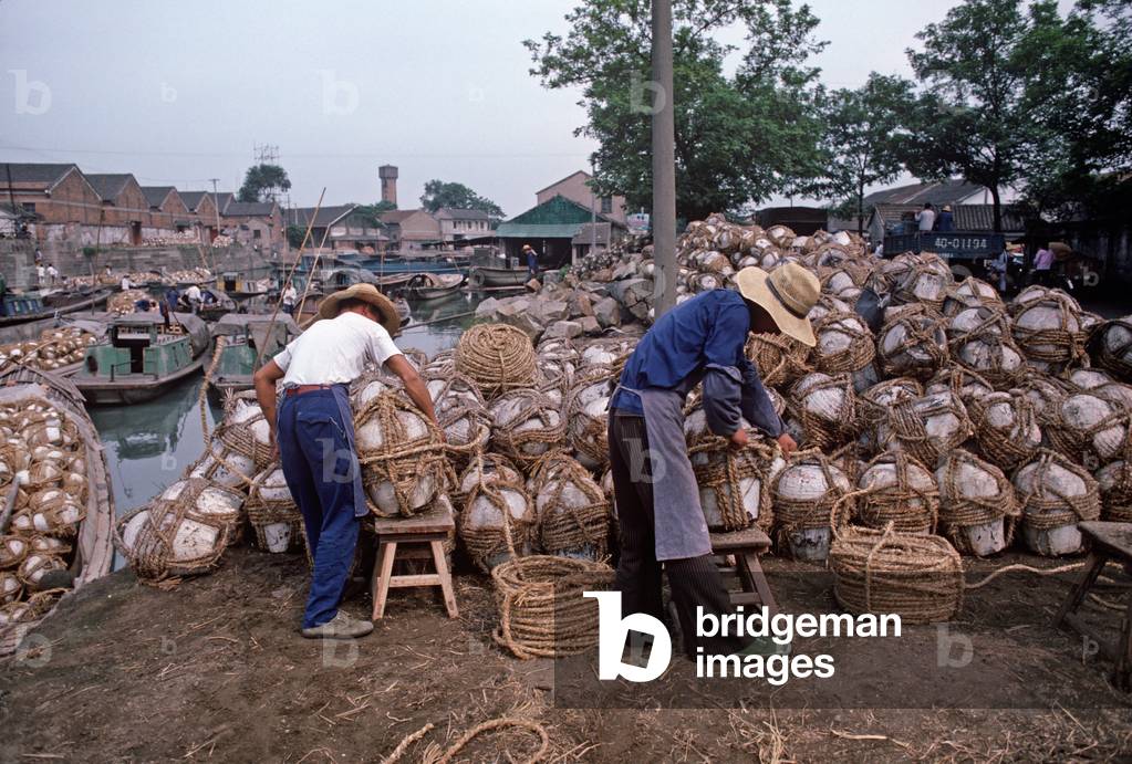 Wrapping hemp cord around rice wine containers, Shaoxing, China (photo)