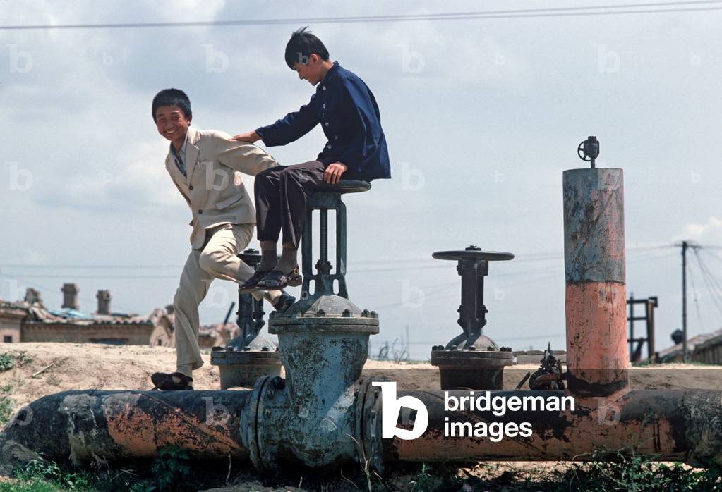 Children playing on oil field installations, Daqing, Heilongjiang Province, China (photo)