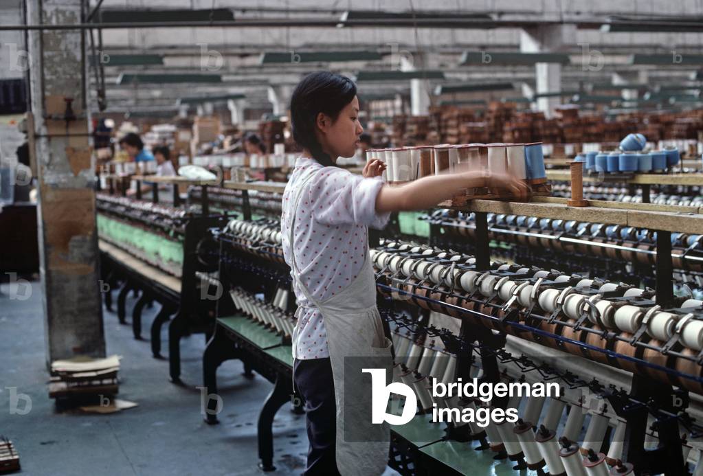 Spools of silk being put on to bobbins ready for weaving in the Chinese Silk Process, Hangzhou Silk Company factory, Hangzhou, Zheijang Province, China (photo)