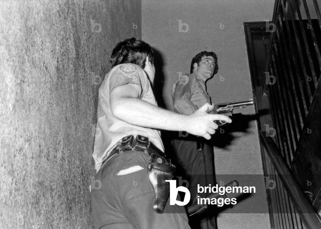28th Precinct, New York policeman with guns drawn in Harlem, USA, 1970s (b/w photo)