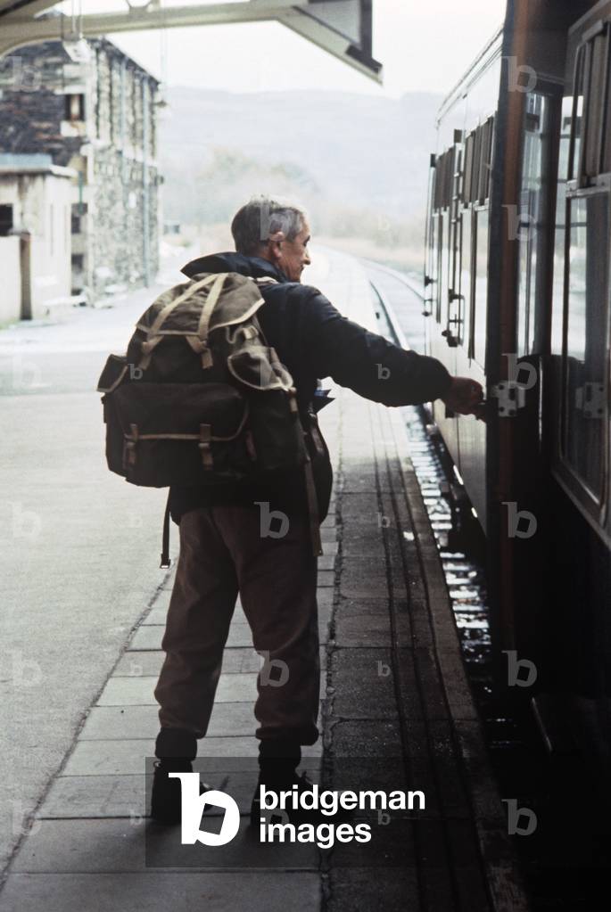 Hiker getting on the Oxenholme to Windermere train in the Lake District, England, 1981 (photograph)