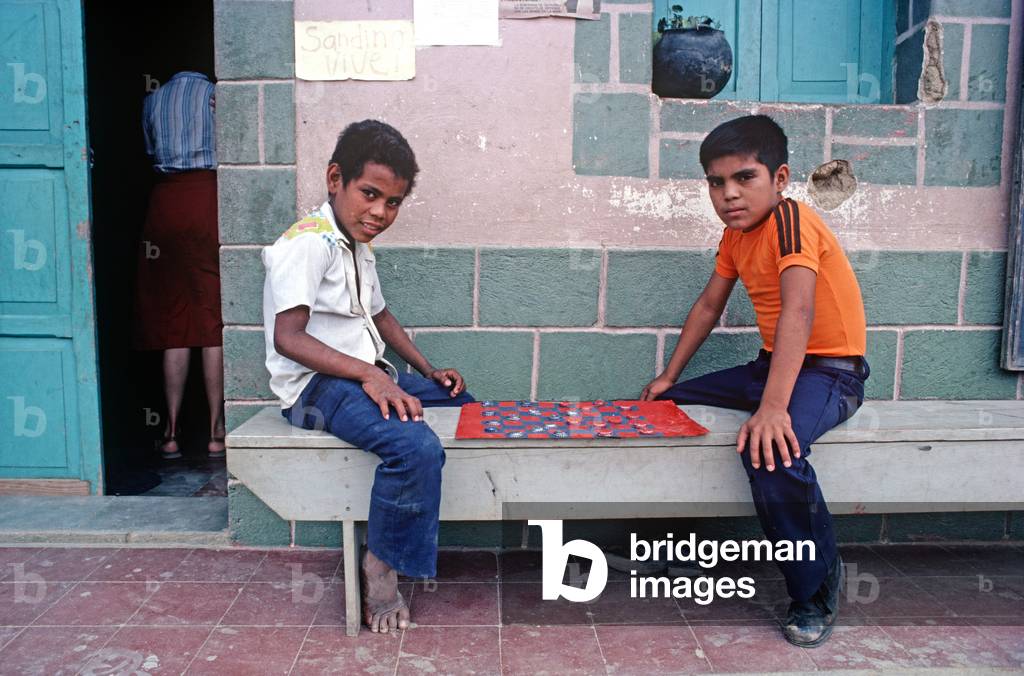 Boys playing checkers game with bottle tops, Santa Maria, a small village on the border with Honduras, Nicaragua, Central America (photo)