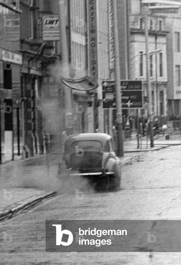 British Army bomb disposal soldier blowing boot of bomb bobby trapped car in Belfast, early 70s, Northern Ireland, 1972 (b/w photo)