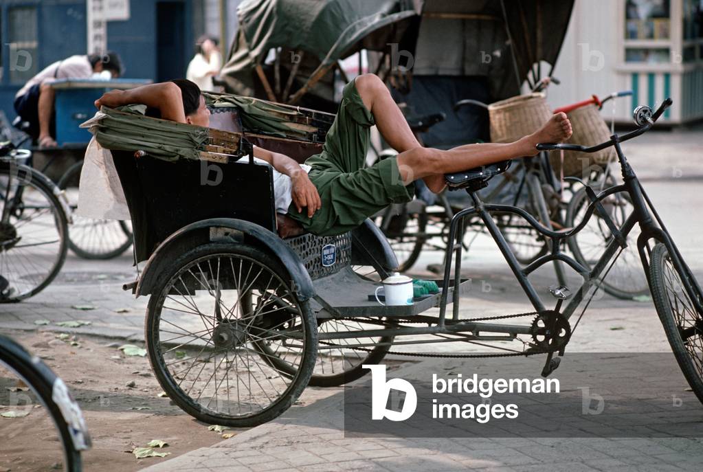 Bicycle taxi cyclist resting between fares, Chengdu, Sichuan Province, China (photo)