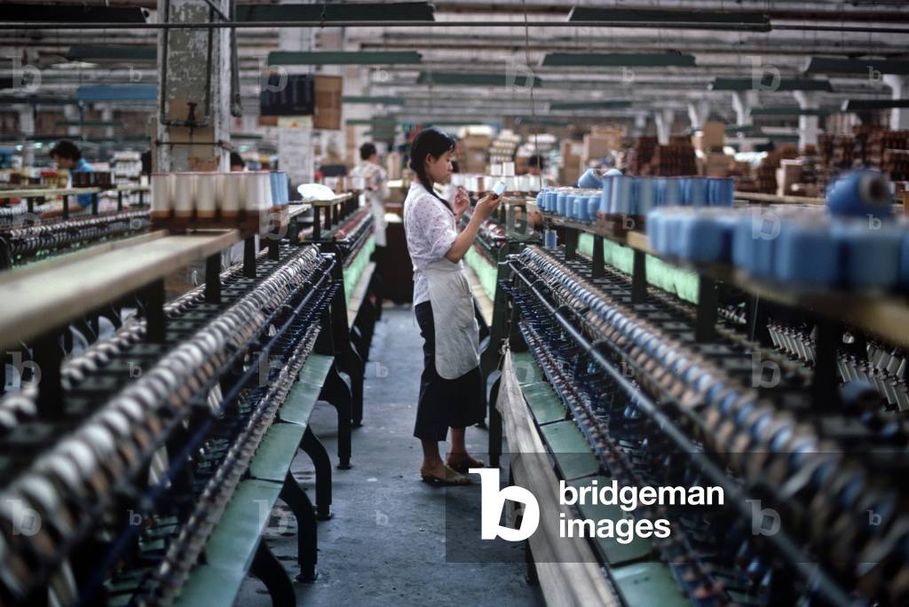 Spools of silk being put on to bobbins ready for weaving in the Chinese Silk Process, Hangzhou Silk Company factory, Hangzhou, Zheijang Province, China (photo)
