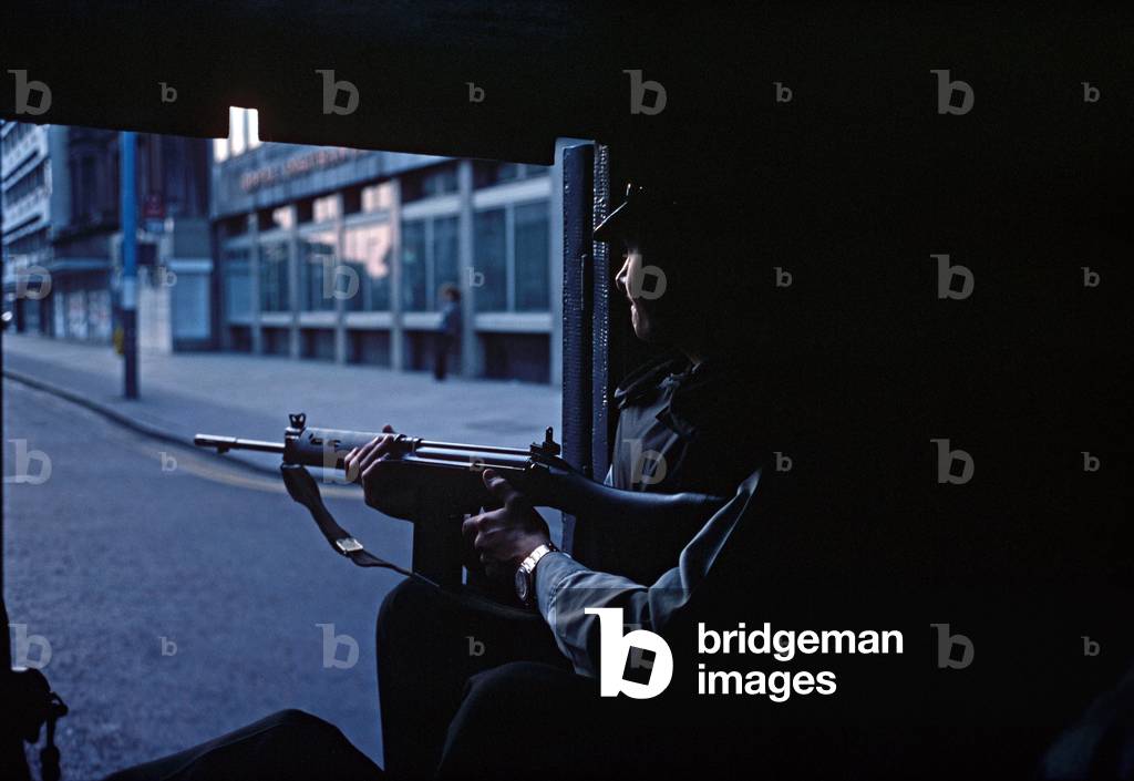 RUC, Royal Ulster Constabulary policeman on Patrol in back of Armoured Land Rover during The Troubles, Belfast City Centre, Northern Ireland, 1978 (photo)