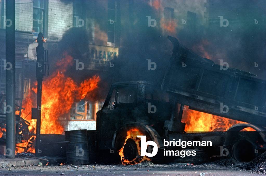 Burning Hijacked Vehicles during Riots on The Falls Road, West Belfast during The Troubles, Northern Ireland, 1976 (photo)