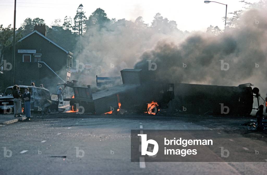 Burning Hijacked Vehicles during Riots on The Falls Road, West Belfast during The Troubles, Northern Ireland, 1976 (photo)