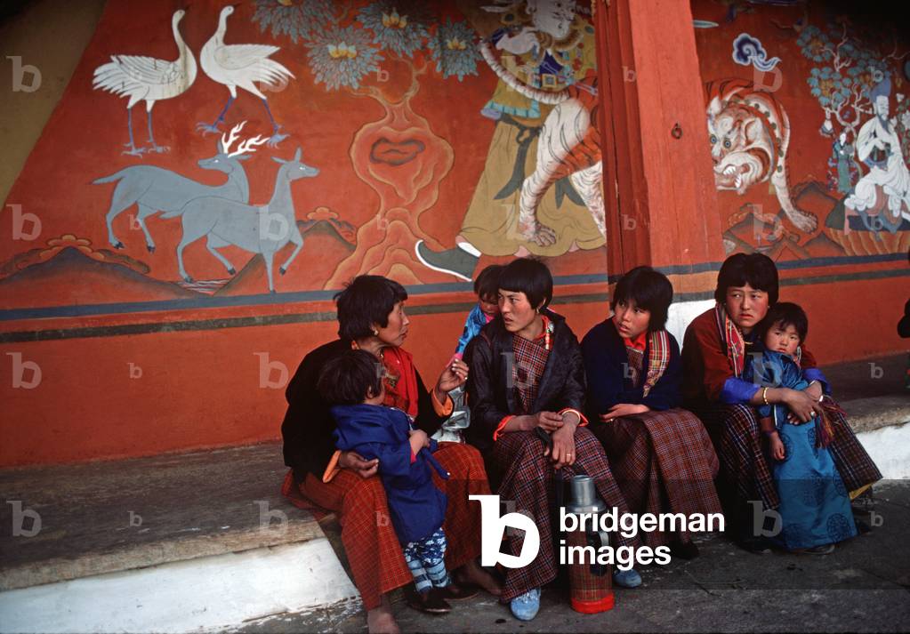 Bhutanese in front of chained Tiger mural, Paro monastery, Dzong,  Bhutan (photo)