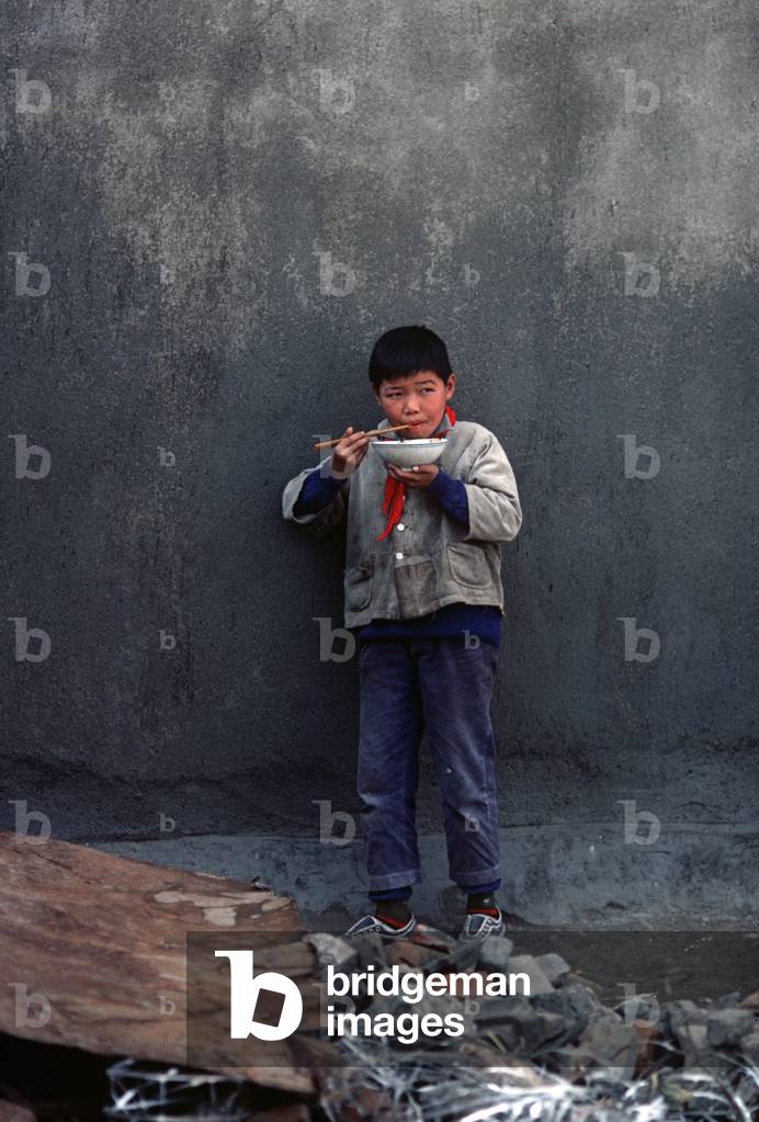 Boy eating lunch with chopsticks, Hung-Chiao commune, 1979 (photo)