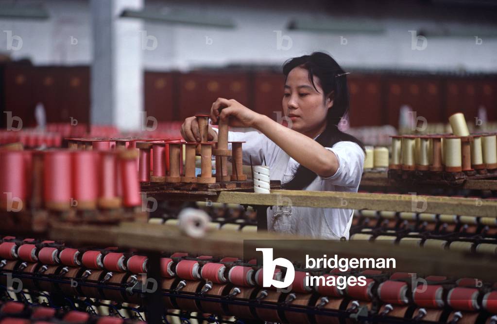 Spools of silk being put on to bobbins ready for weaving in the Chinese Silk Process, Hangzhou Silk Company factory, Hangzhou, Zheijang Province, China (photo)