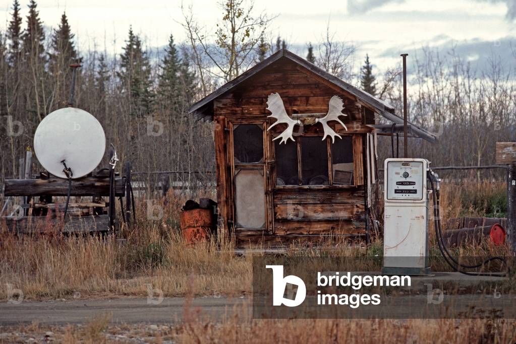 Bonanza Creek log cabin and gasoline pumps near Dawson City, Yukon, Canada (photo)