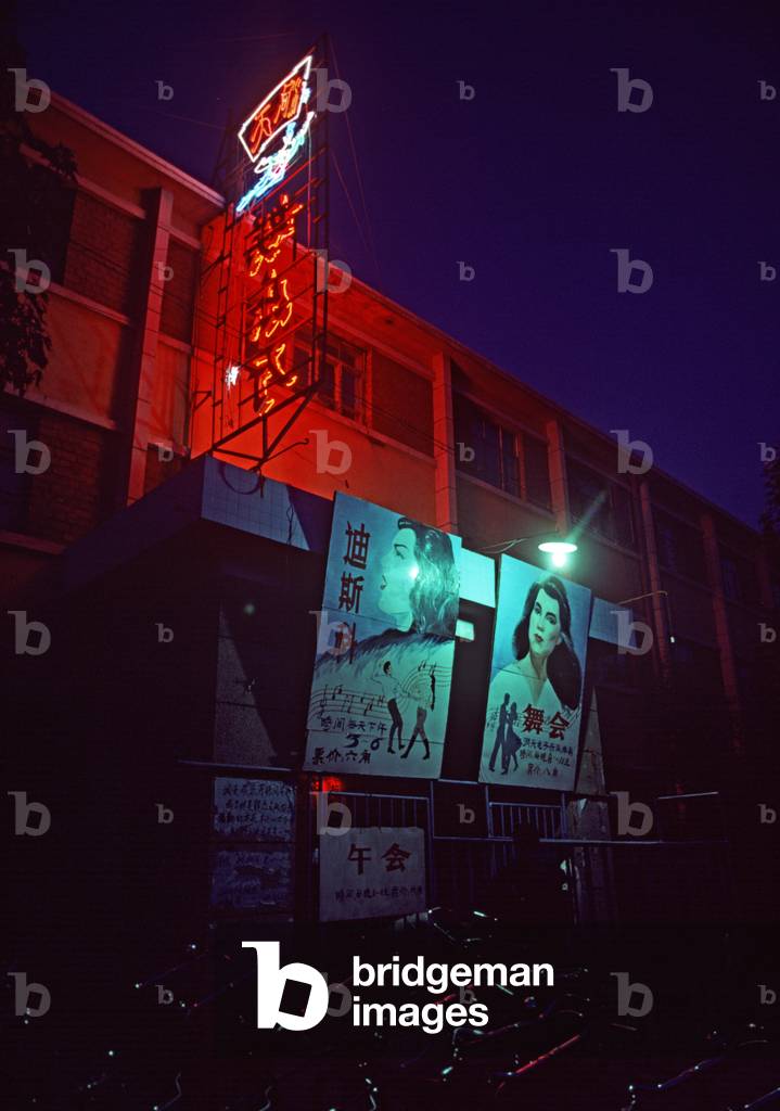Dancing and music posters at night outside underground bomb shelter used as dance center and nightclub in Harbin, Heilongjiang Province, China (photo)