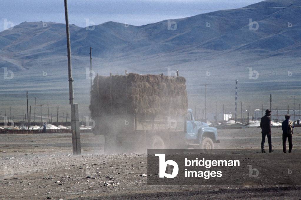 Truck raising dust trail outside Yurt Village in Gobi-Altai, Gobi Desert, Mongolia, Asia