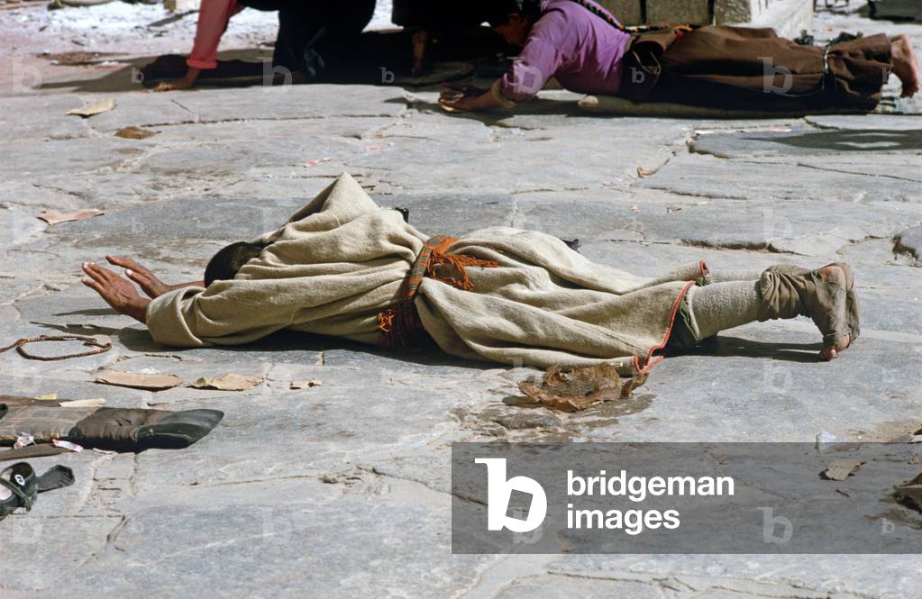 Buddhist pilgrims prostrating themselves in front of Jokhang Temple, Lhasa, Tibet (photo)