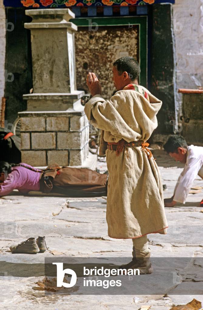 Buddhist pilgrims prostrating themselves in front of Jokhang Temple, Lhasa, Tibet (photo)