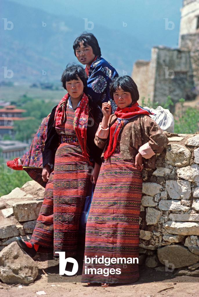 Bhutanese girls in traditional costumes at the Paro Tshechu, mask dance festival, in the Paro Dzong, Bhutan (photo)